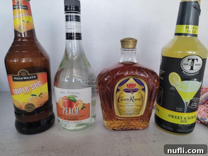 Bottles of triple sec, peach schnapps, crown royal, and sweet and sour mix in a row