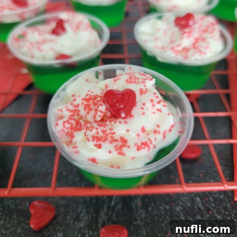Green grinch jello shot with red heart on a red drying rack