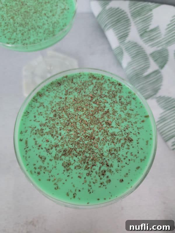 Looking down into a green cocktail with chocolate shavings floating as a garnish