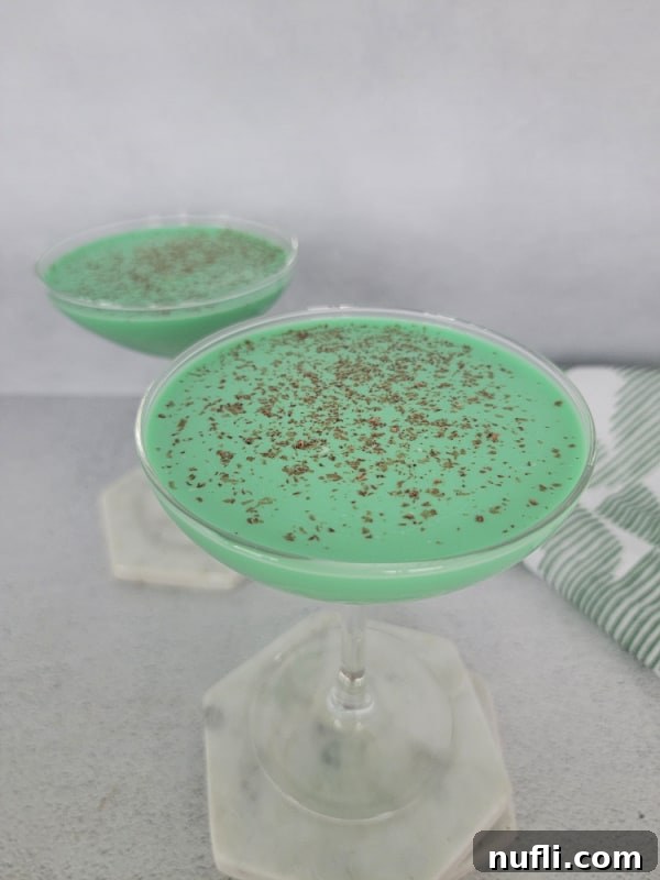 Green cocktails in coupe glasses sitting on marble coasters