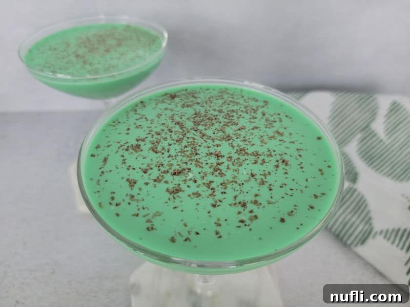 Green cocktails with chocolate shavings on them next to a cloth napkin