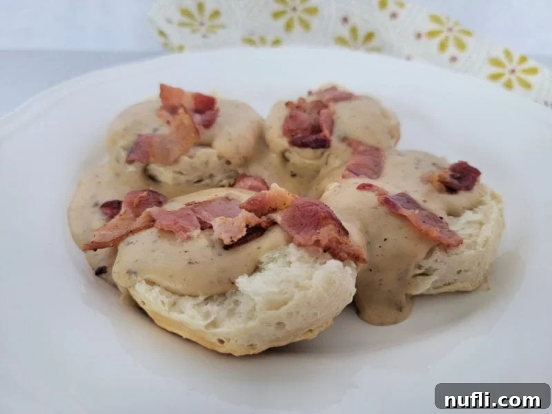 bacon gravy and biscuits on a white plate