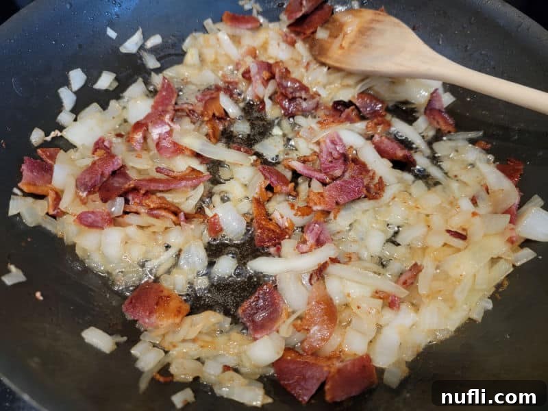 Wooden spoon in a frying pan with bacon and onions