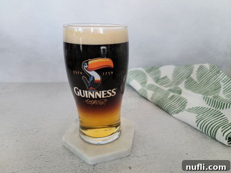 Guinness glass with layered drink next to a cloth napkin 