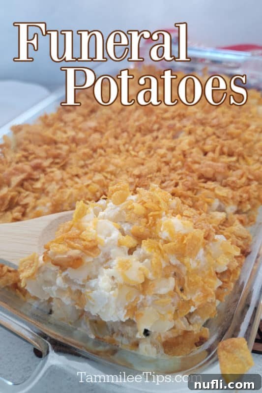 Funeral Potatoes over a glass baking dish with a wooden spoon scooping potatoes