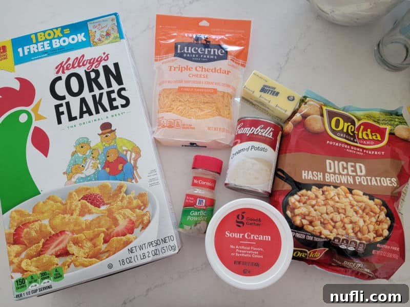 Corn Flakes, Cheddar cheese, cream of potato soup, garlic powder, sour cream, diced hash brown potatoes, and butter on a counter
