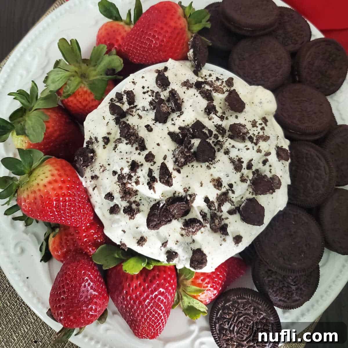 Oreo Fluff in a white bowl next to strawberries and oreo cookies