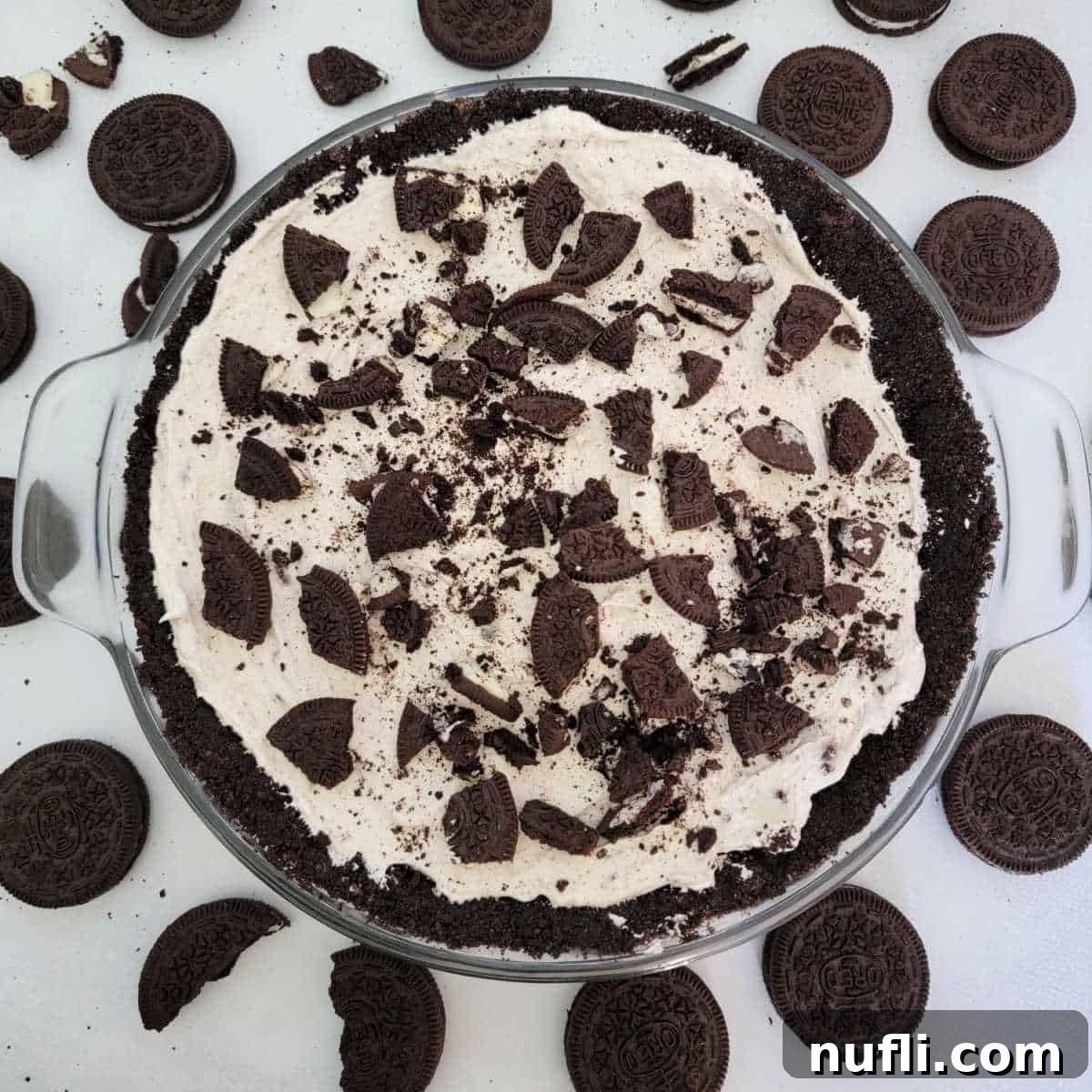 No bake Oreo cheesecake in a glass dish surrounded by Oreo Cookies
