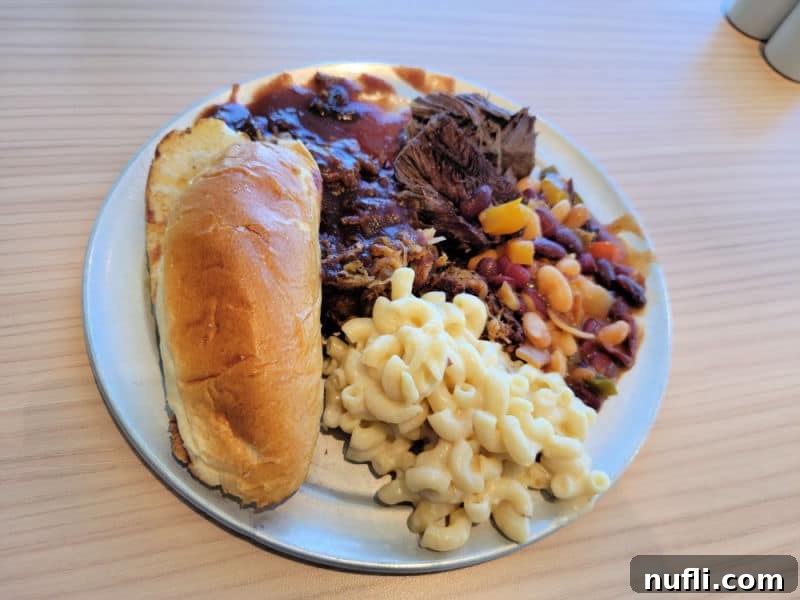 Carnival Radiance 4-Day Baja Mexico Escape 18 brisket, beans, mac and cheese, and a roll on a white plate