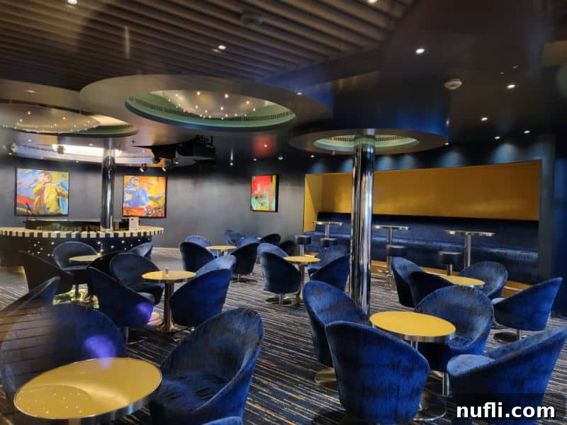 Blue velvet chairs next to yellow topped tables in a lounge area