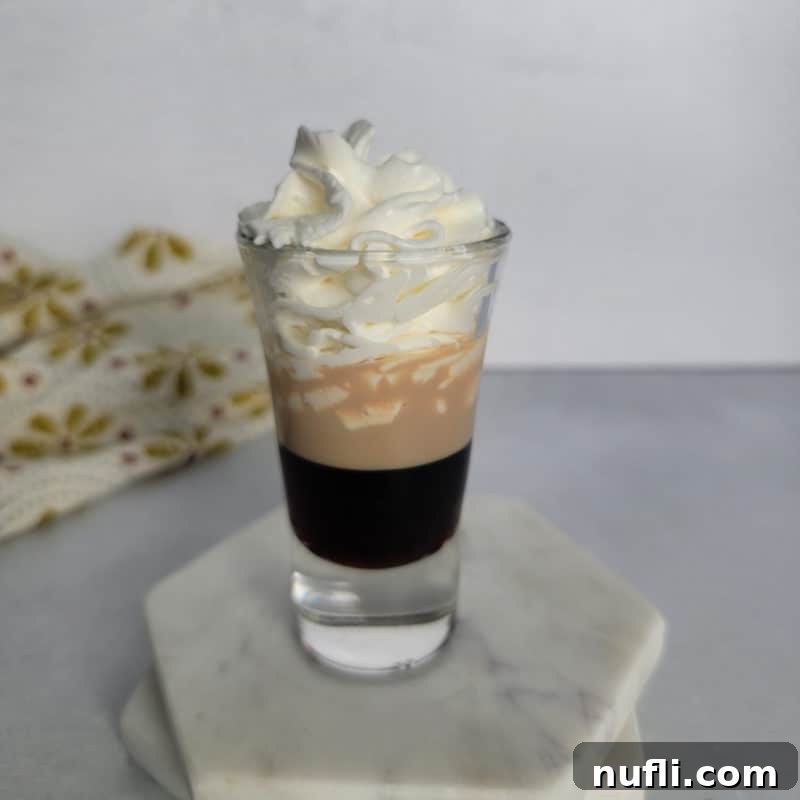 Blow Job Shot layered in a shot glass on a white coaster.