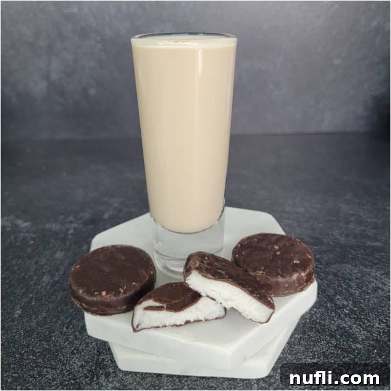 Peppermint patty chocolate next to a shot glass filled with peppermint patty shot.