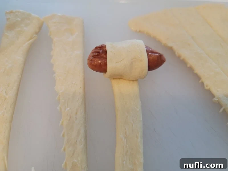 Petite Sausage Parcels 5 Little smokie sausage starting to be wrapped in crescent dough