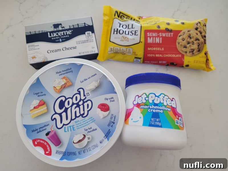 Cream cheese, mini chocolate chips, Cool Whip Lite, and marshmallow creme on a white counter