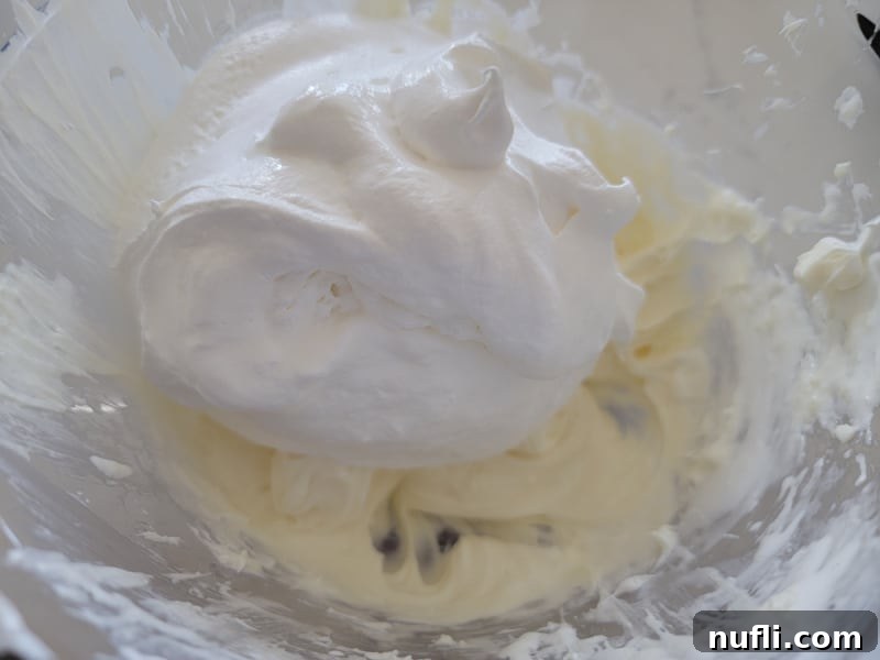 Cool whip on cream cheese mixture in a glass bowl 