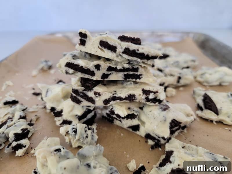 Effortless Two-Ingredient Oreo Bark 8 Stack of hardened Oreo Bark pieces on a parchment-lined baking sheet, ready to be served or gifted.
