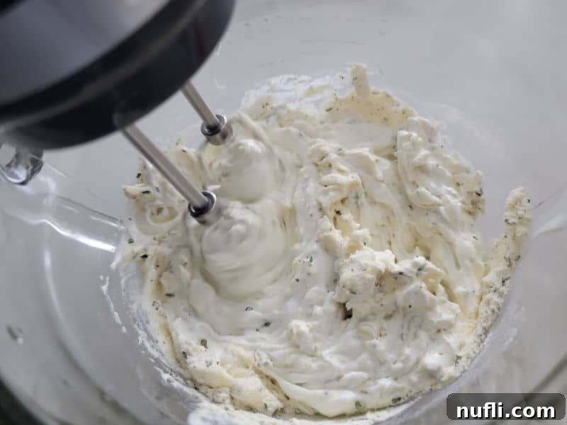 Quick 3-Ingredient Potato Chip Dip 5 mixer beaters mixing sour cream and ranch seasoning in a glass bowl