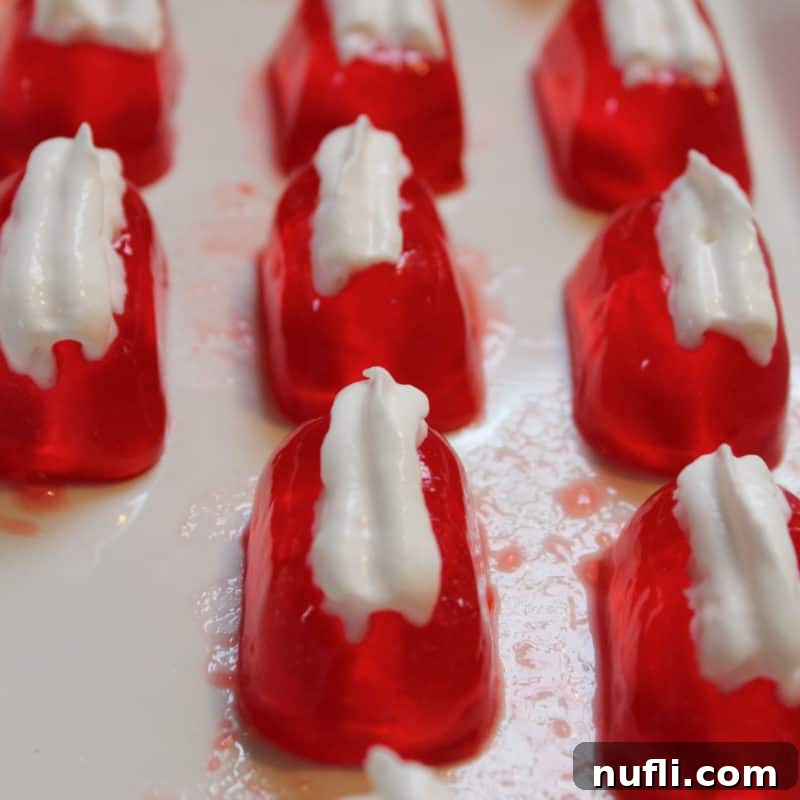 Tropical Malibu Rum Creations 7 Strawberry Daiquiri Jello Shots on a white platter garnished with whipped cream