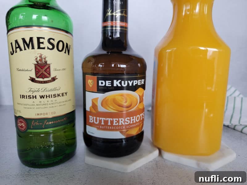 Bottle of Jameson Irish Whiskey, Bottle of Buttershots, and bottle of orange juice.