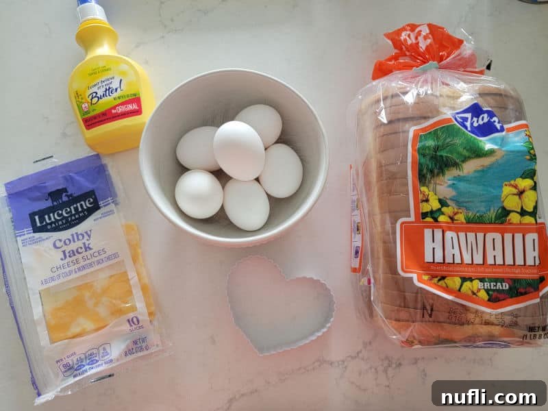 colby jack cheese, butter, eggs, a heart cookie cutter, and loaf of bread
