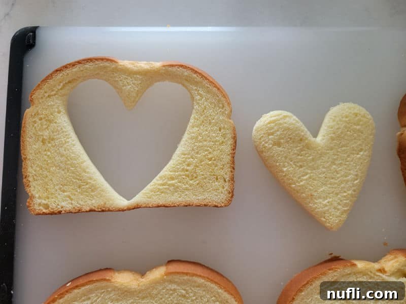 heart cut out of a piece of bread on a cutting board