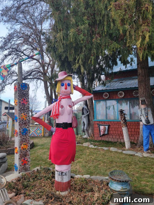 big red statue made with random parts next to other yard art in Ellensburg