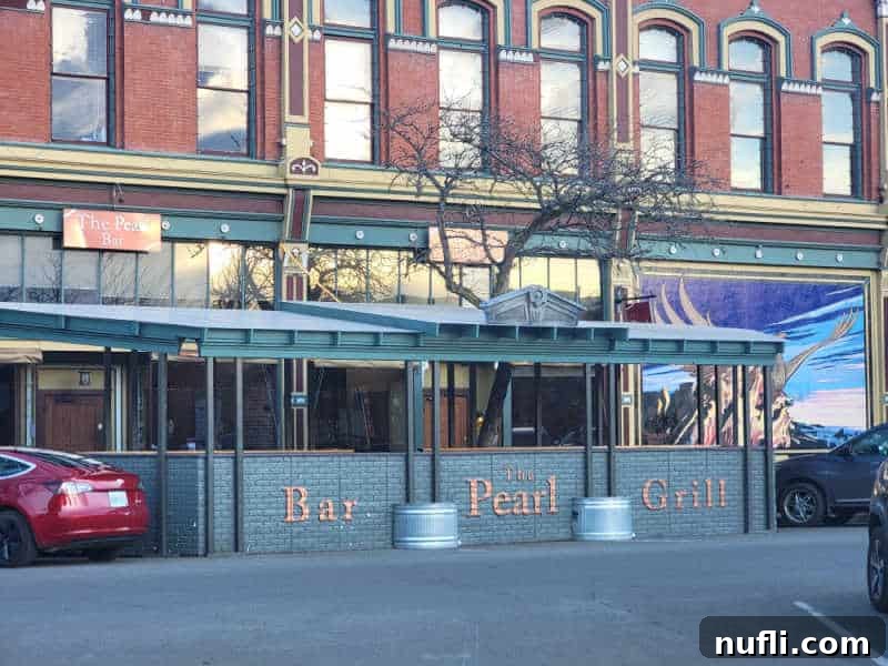 The Pearl Bar & Grill sign next to a restaurant with a large mural 