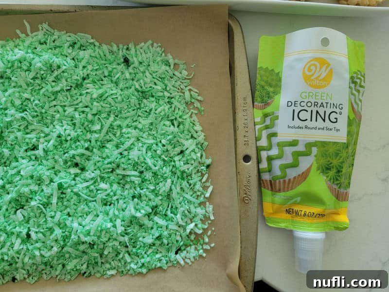 Coconut grass on a baking sheet next to Wilton green icing
