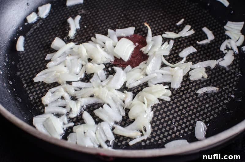 Hearty Corned Beef Shepherds Pie 4 onions browning in a skillet