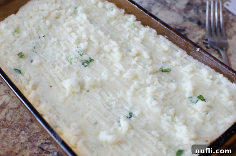 Hearty Corned Beef Shepherds Pie 7 mashed potatoes in a casserole dish