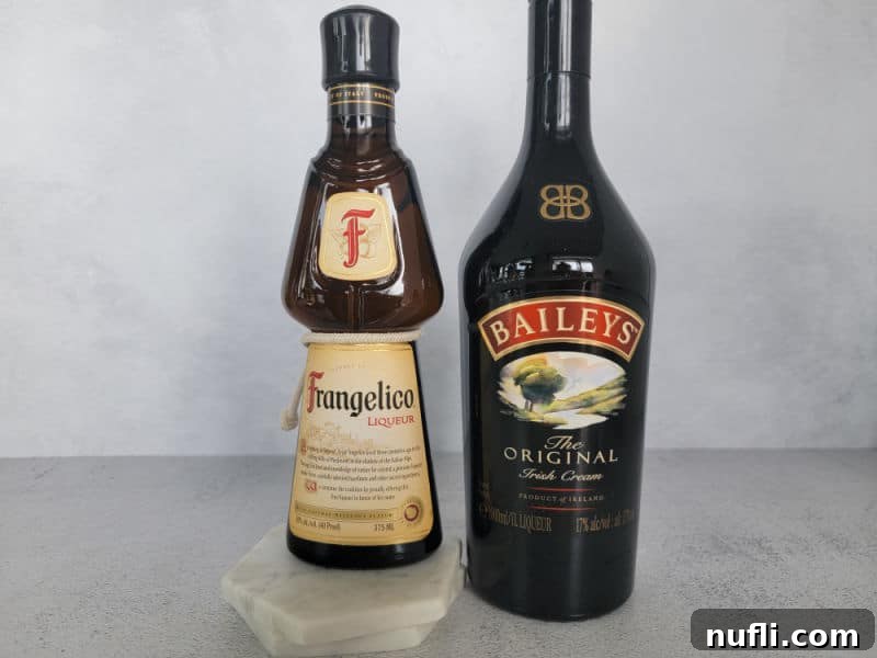 Frangelico hazelnut liqueur bottle and Baileys Irish Cream bottle sitting on a grey kitchen counter, ready for mixing a Nutty Irishman cocktail.