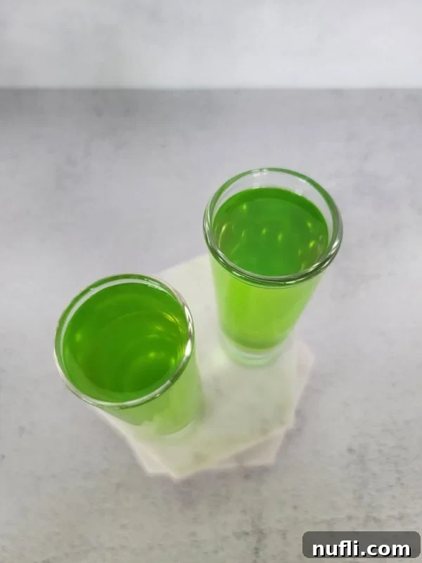 Looking down on two shot glasses filled with green liquid