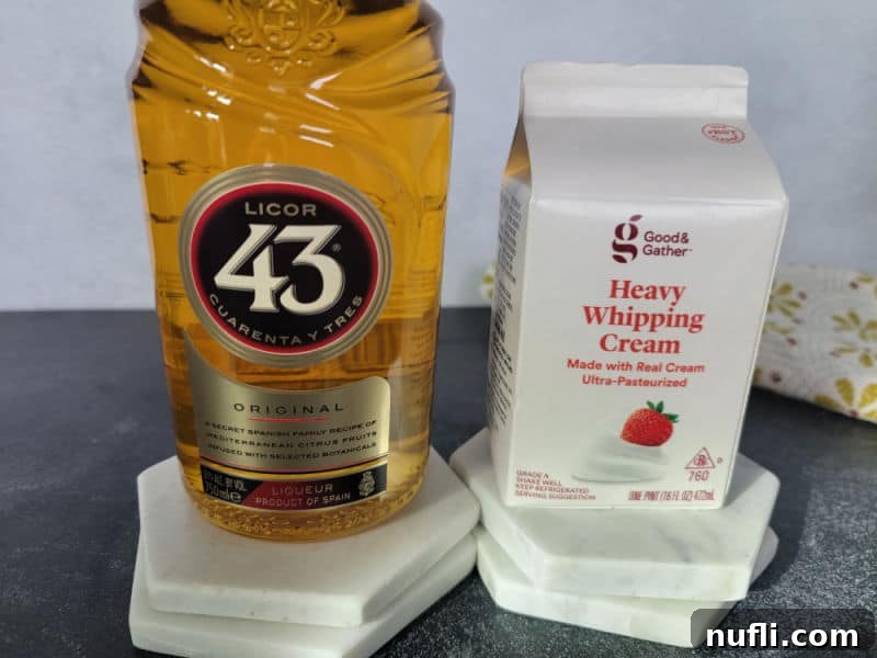 Licor 43 bottle next to a container of Heavy Whipping Cream. 