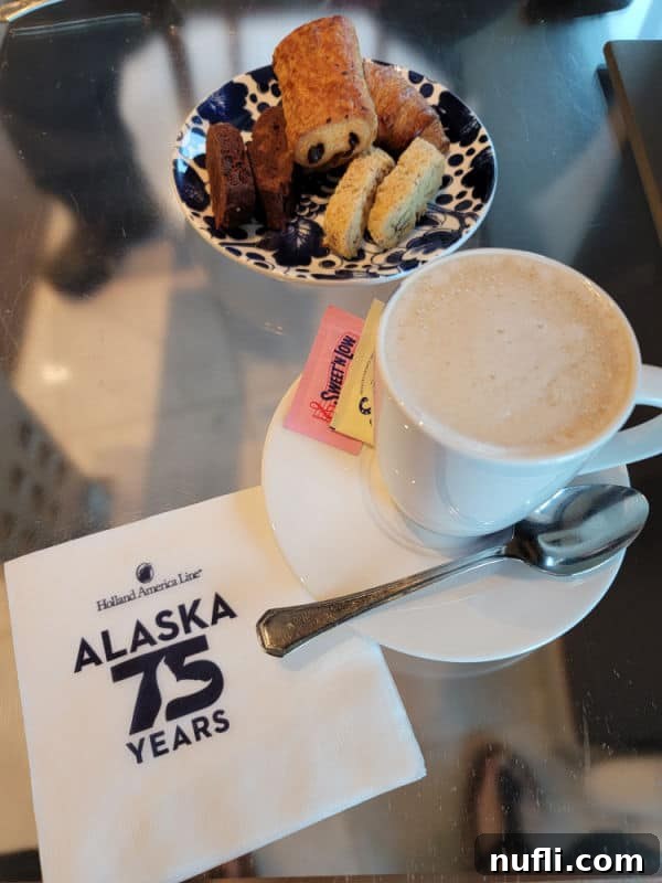 A Holland America napkin, a small plate of cookies, and a beautifully presented chai tea latte, setting a relaxing morning scene.