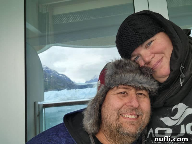 Tammilee and John on the cruise ship balcony with a glacier in the background