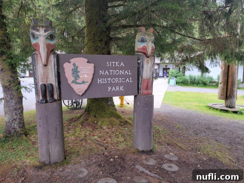 Sitka National Historical Park sign with two totem poles