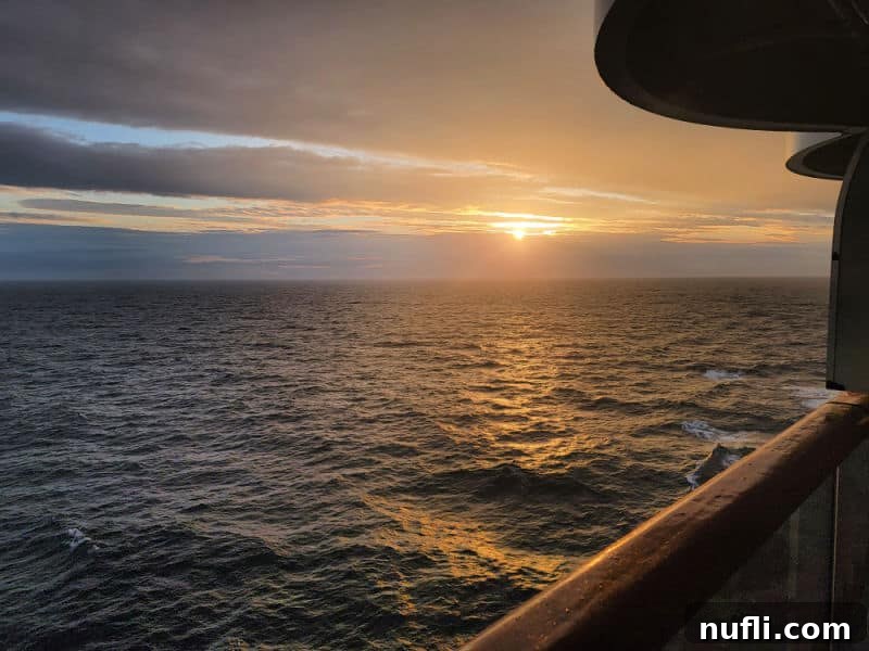 A serene view from the cruise ship balcony, capturing a beautiful sunset over the sea, a perfect end to an Alaskan day.