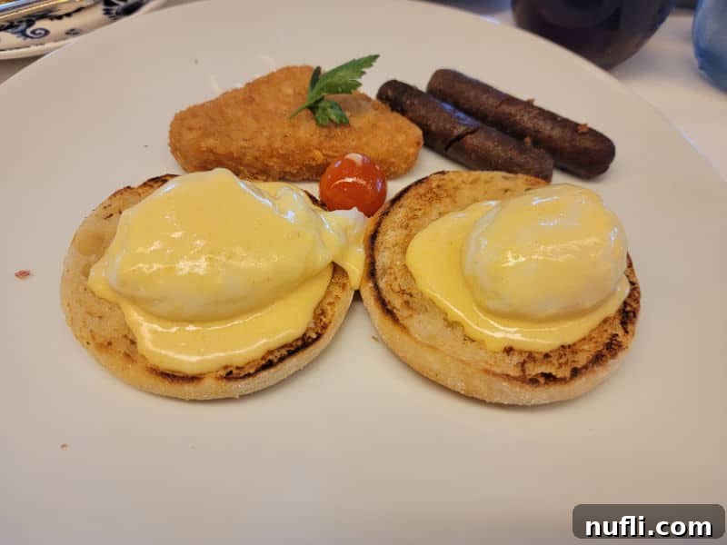eggs benedict with a hashbrown and sausage on a white plate