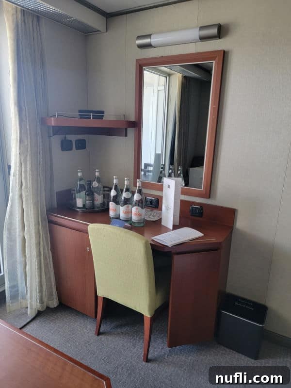 Wooden desk on the eurodam with bottles of water, mirror, and a chair