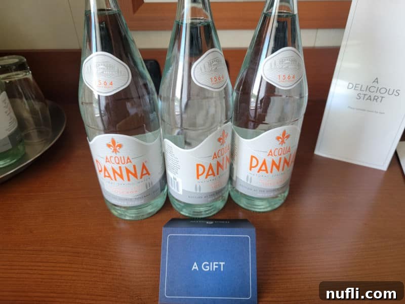 Three glass bottles of Acqua Panna water on a desk 
