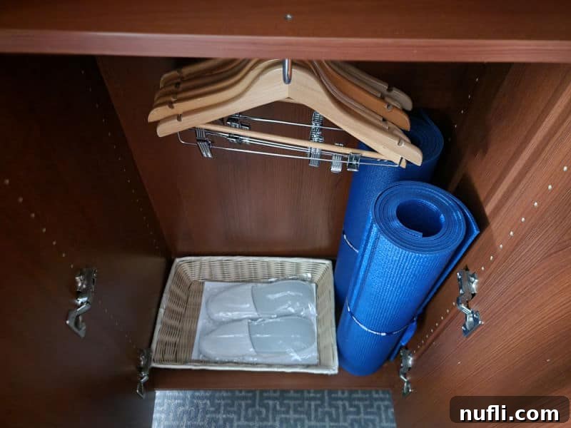 two yoga mats rolled in a closet with slippers and hangers