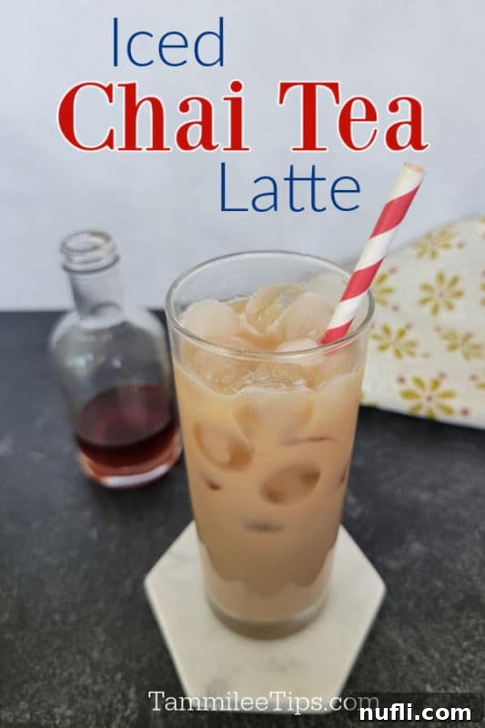 Iced Chai Tea latte over a glass with chai tea, a striped straw, and a bottle of chai syrup