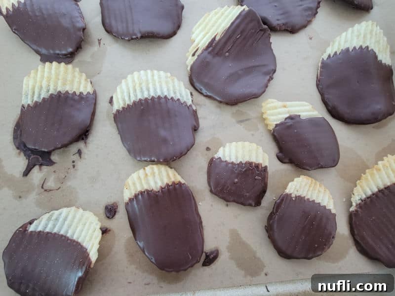 A close-up view of chocolate-dipped Ruffles potato chips arranged artfully on parchment paper, ready to be enjoyed.