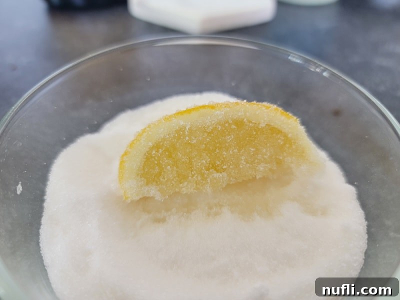 A lemon slice meticulously covered in granulated sugar, ready to be paired with the Chocolate Cake Shot.