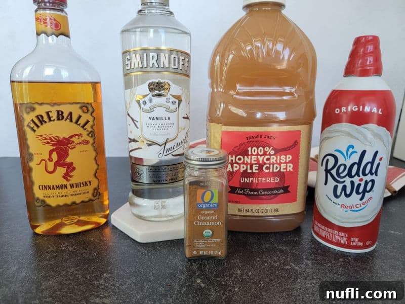 Apple Pie In A Shot Glass 3 Fireball cinnamon whiskey, vanilla vodka, ground cinnamon, apple cider, and whipped cream can on a counter