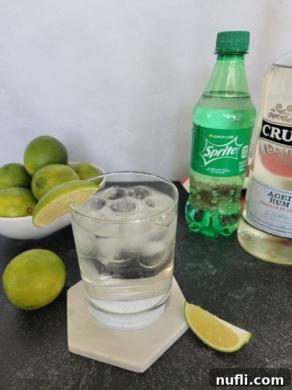 2 ingredient sprite and rum cocktail next to a bowl of limes and a bottle of Sprite