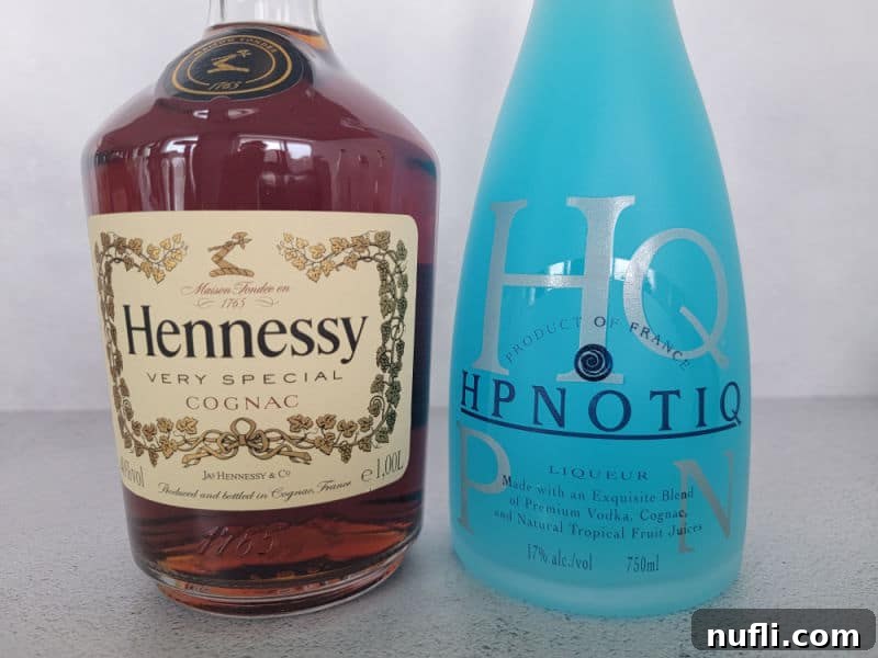 Gamma Ray Gulp 3 Hennessy very special cognac bottle next to a blue Hpnotiq bottle