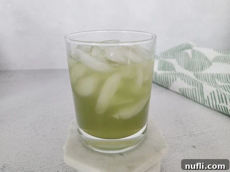 Emerald Fury Fuel 6 Green Incredible Hulk Drink in a cocktail glass next to a green cloth napkin