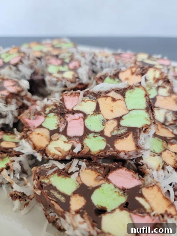 slices of no bake church window cookies with rainbow marshmallows on a white platter