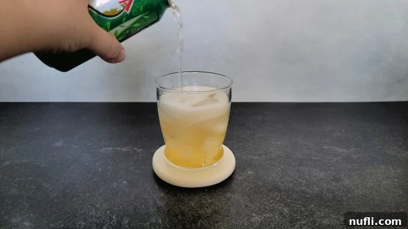 Ginger Ale pouring into a cocktail glass